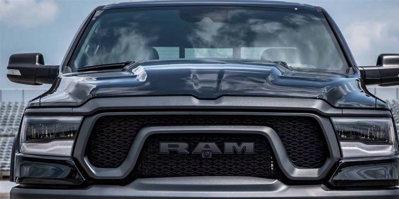 Close-up image of the 2024 RAM 1500 featuring the front grill, headlights, and the RAM emblem