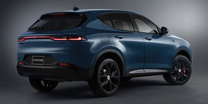 Image of the blue 2024 Dodge Hornet shot facing away from the camera at an angle with a plain gray backdrop