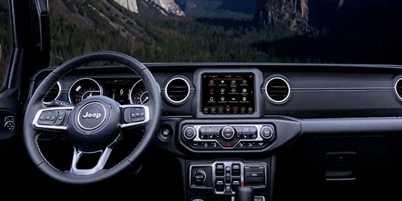 Image of the interior front dashboard of the 2024 Jeep Wrangler 4xe, featuring the Uconnect® infotainment system