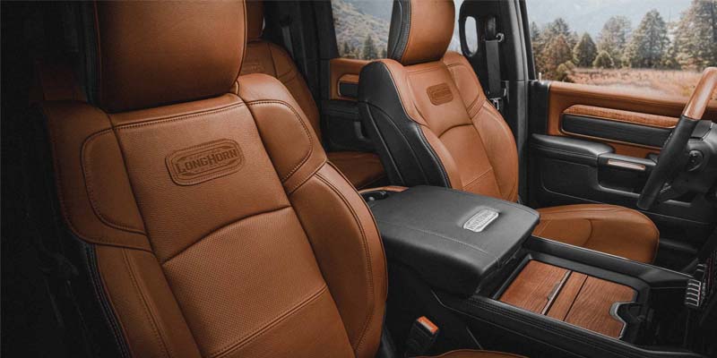 Image of the interior of the 2024 RAM 2500, featuring brown leather and real wood interiors on the Longhorn trim level