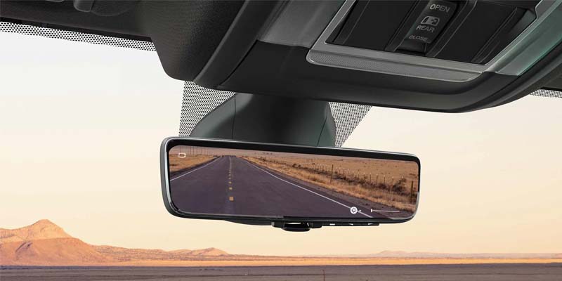 Image of the rearview mirror inside the 2024 RAM 2500 with a desert road reflected in the mirror